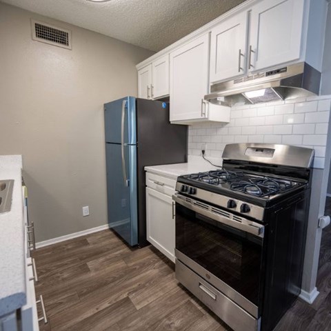 A kitchen with a stove, oven, and refrigerator.