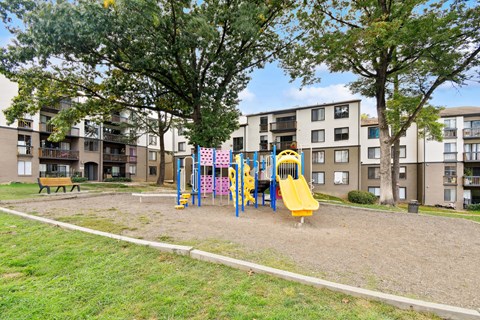 A playground with a yellow slide and a yellow slide in the middle of the playground.