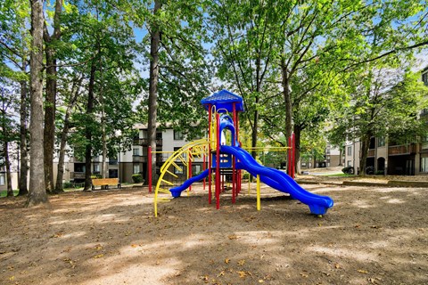 A playground with a blue slide and yellow structure.
