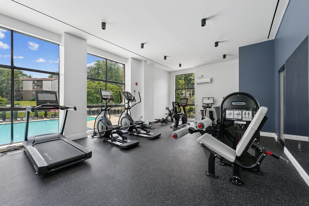 A spacious home gym with a treadmill, exercise bike, and other equipment.
