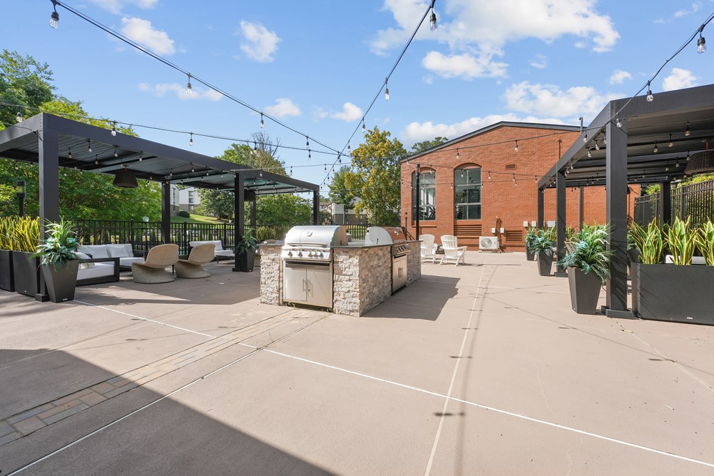 A patio area with a black awning and a brick building in the background.