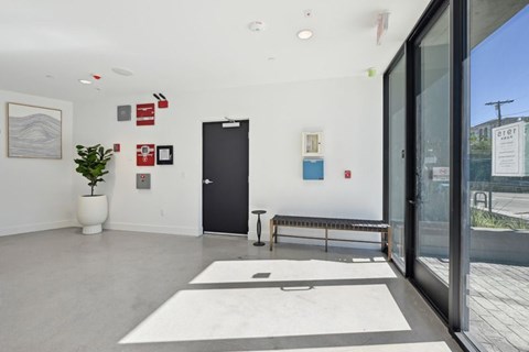 A white hallway with a black door and a bench at 1915 Park, Los Angeles, CA 90026
