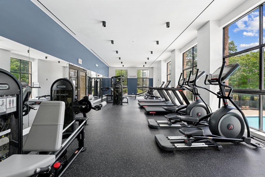 A gym with treadmills, elliptical machines, and other exercise equipment.