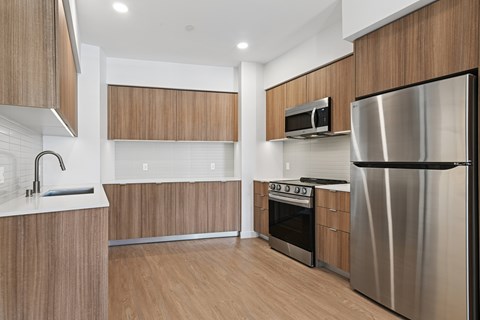 A modern kitchen with wooden cabinets and stainless steel appliances.