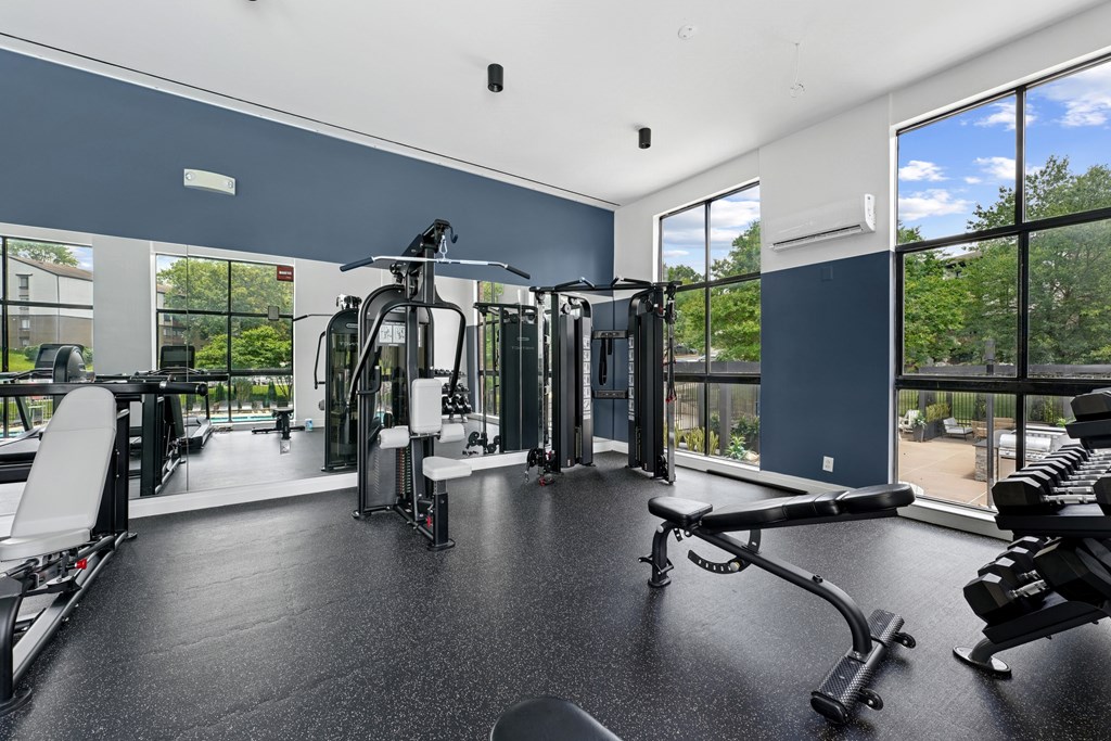 A spacious gym with a variety of equipment and a view of the outdoors.