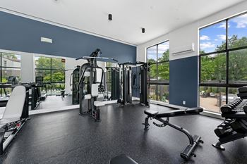 A spacious gym with a variety of equipment and a view of the outdoors.