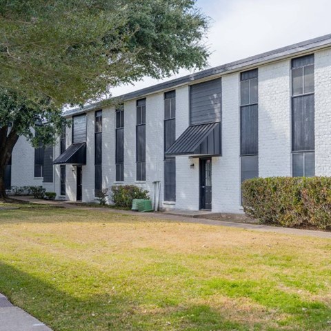 A white building with black awnings and windows.