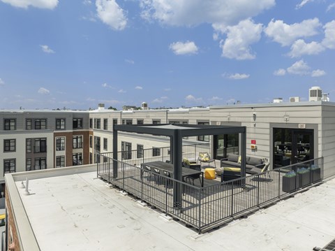 A rooftop patio with a black metal fence and a table and chairs, 28 Austin, Newton, Massachusetts
