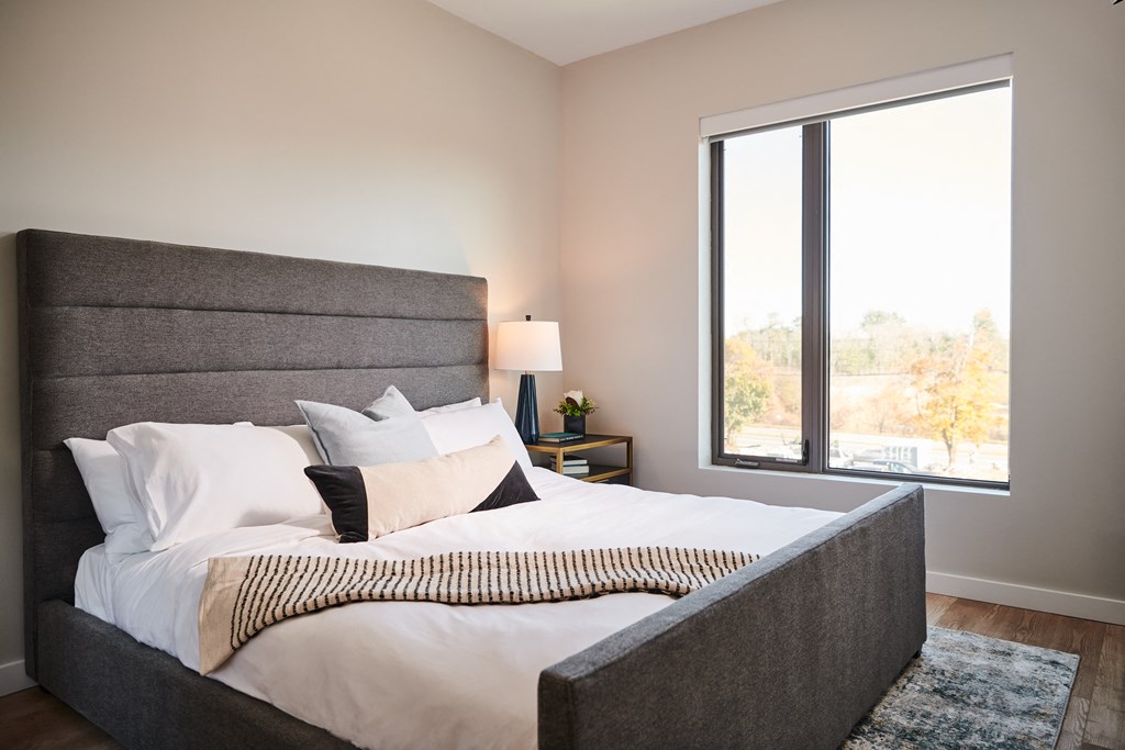 a bedroom with a large bed and a large window