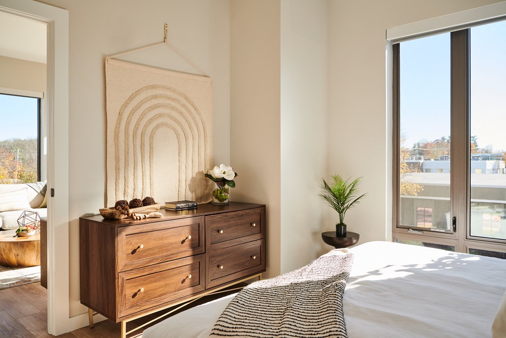 a bedroom with a bed and a dresser and a window