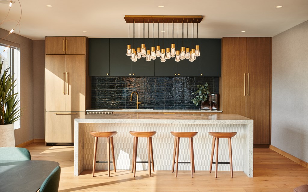 a modern kitchen with a bar and stools