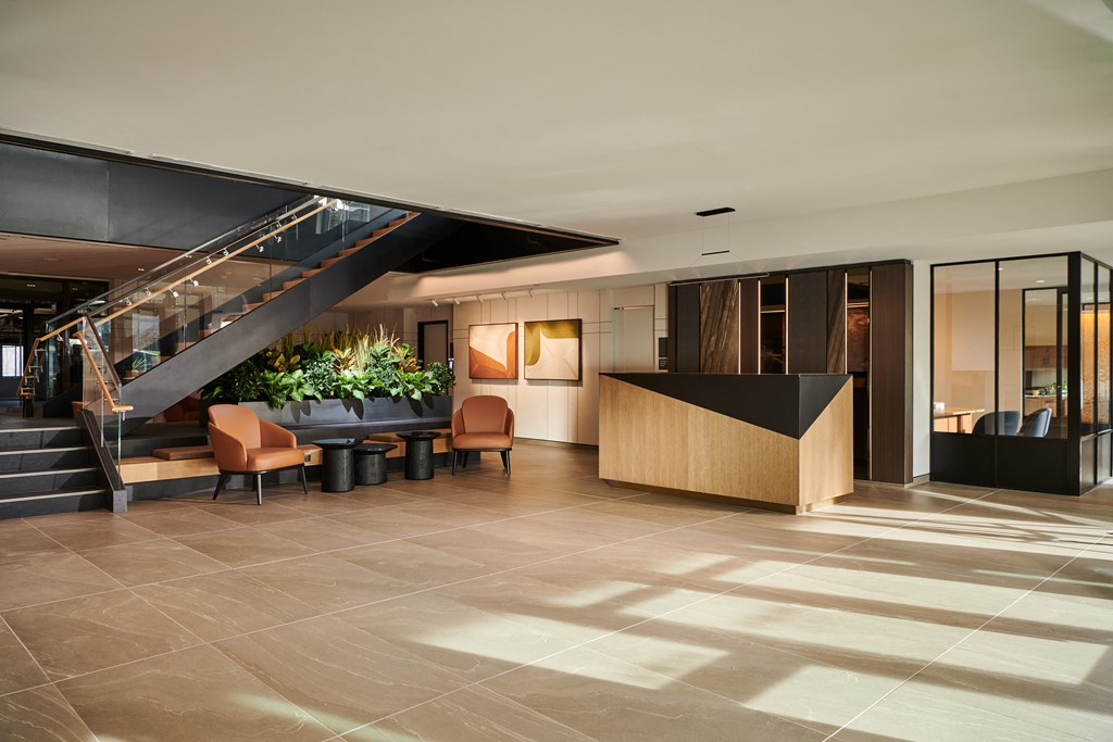 the lobby of a hotel with a staircase and a reception desk