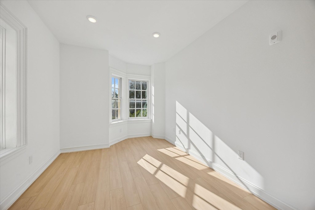 A room with a wooden floor and a window.