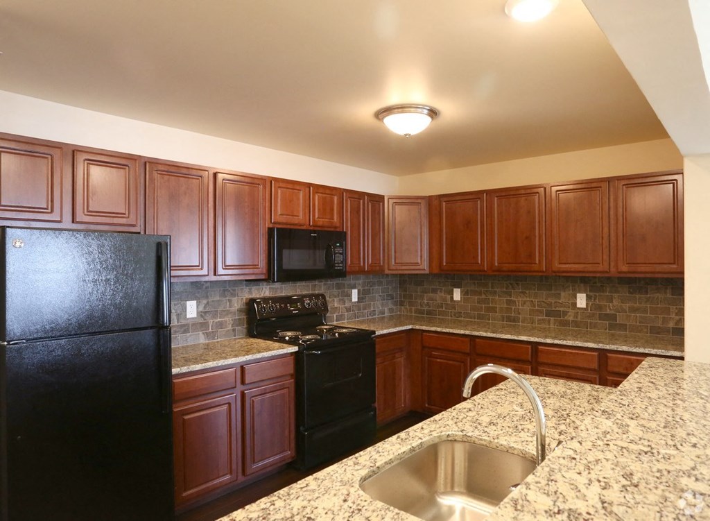 a kitchen with black appliances and granite counter tops