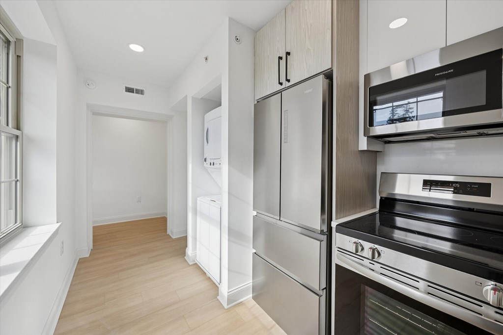 A kitchen with stainless steel appliances and wooden floors.