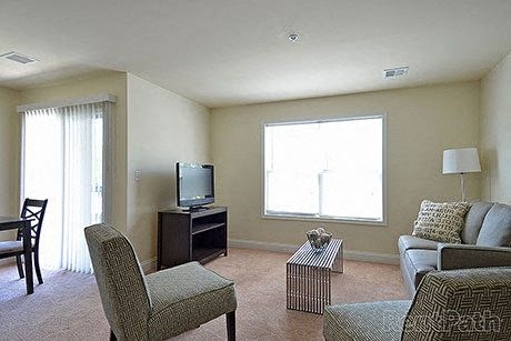a living room with a couch and chairs and a television