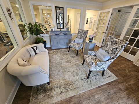 A living room with a white sofa and two chairs.