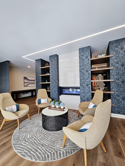 A modern living room with a round coffee table and beige chairs.