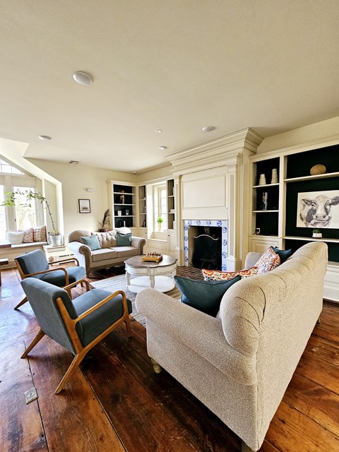 A living room with a grey couch and a wooden floor.