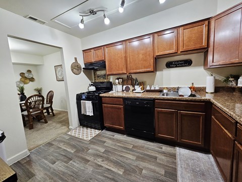 A kitchen with wooden cabinets and black appliances.