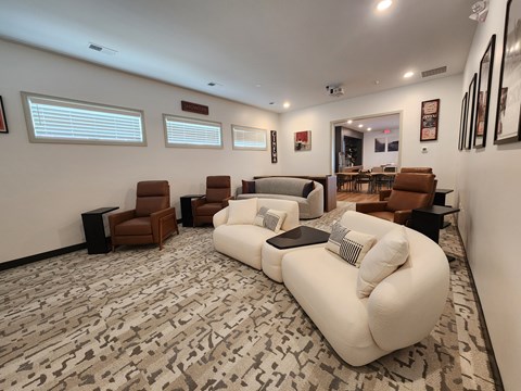 A living room with a white couch and brown chairs.