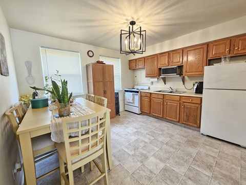 A kitchen with wooden cabinets and a white refrigerator.