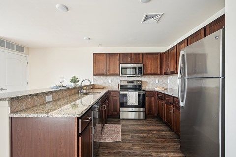A kitchen with wooden cabinets and a granite counter top.