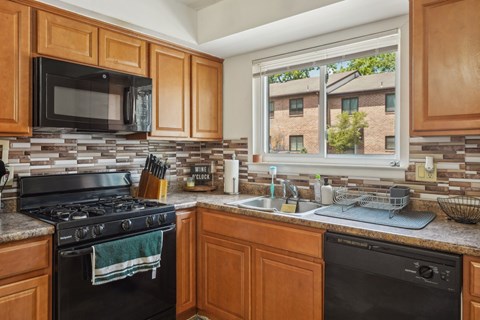 A kitchen with wooden cabinets and a black stove top oven.