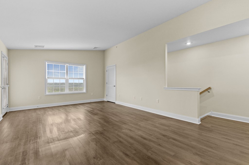 Empty room with wooden floor and white walls.