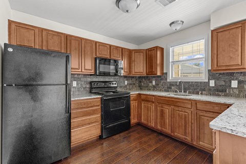 Kitchen with backsplash and granite countertops at The Reserve at Manada Hill