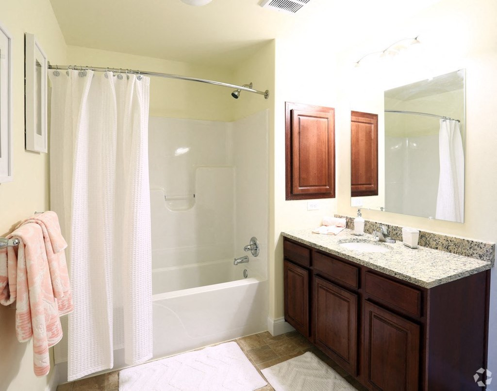 a bathroom with a shower and a sink and a mirror