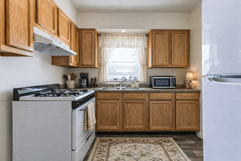 A kitchen with wooden cabinets and a white refrigerator.