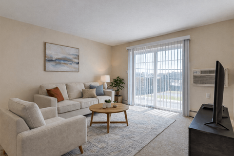A living room with a grey couch, a wooden coffee table, and a painting on the wall.