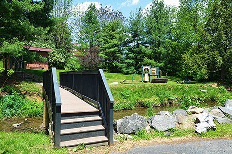 A bridge, creek, and playground at Cambridge Commons Apartments in Wyomissing PA