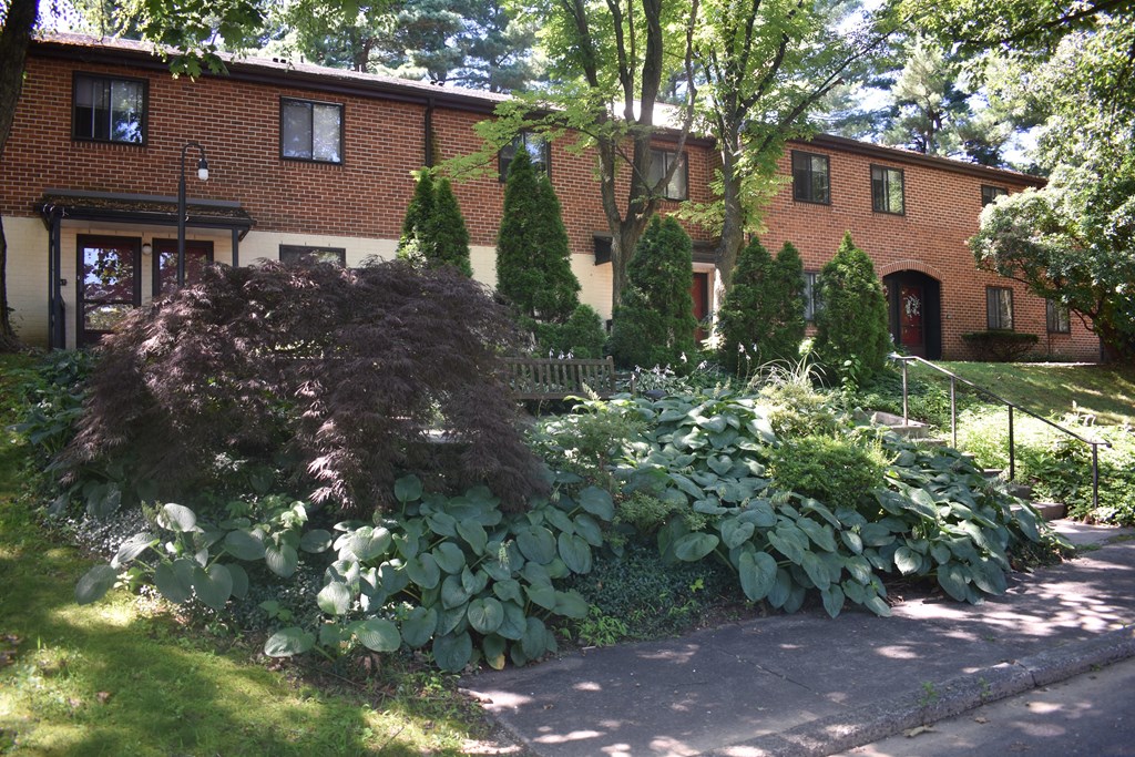 a garden in front of a brick building