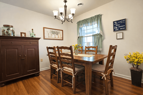 A dining room with a wooden table and chairs.