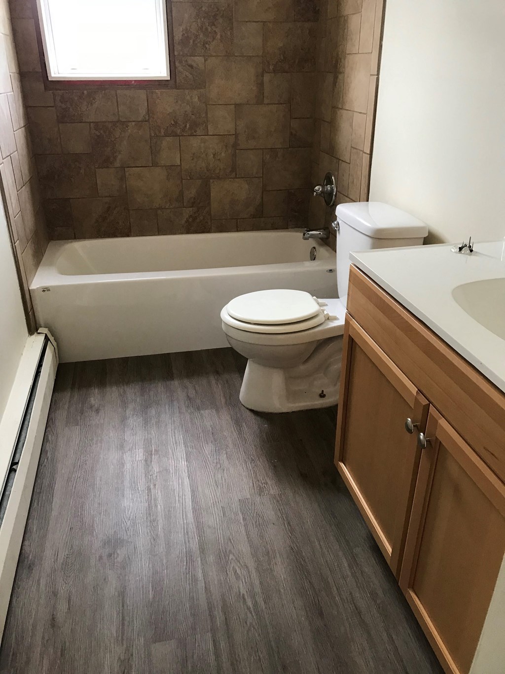 a bathroom with a toilet and a tub and a sink