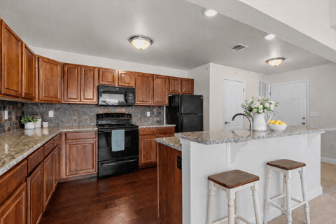 A kitchen with brown cabinets and a black oven.