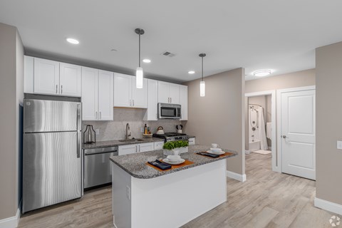 A modern kitchen with a stainless steel refrigerator and a central island.