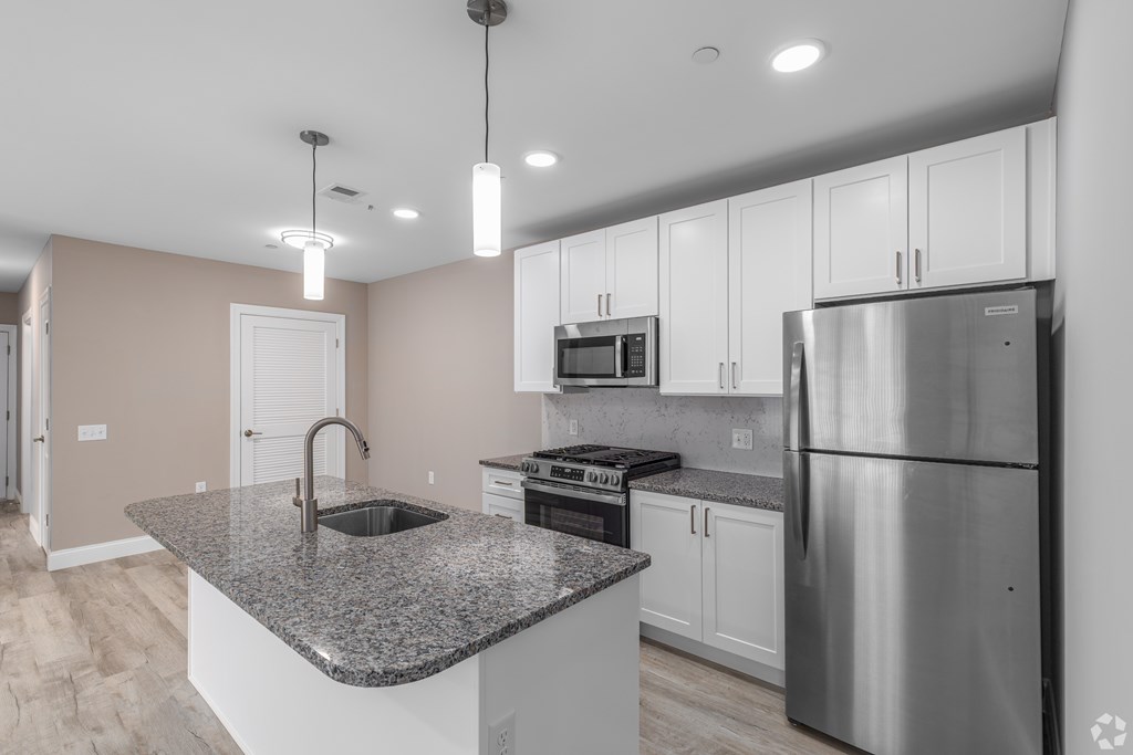 A modern kitchen with granite countertops and stainless steel appliances.
