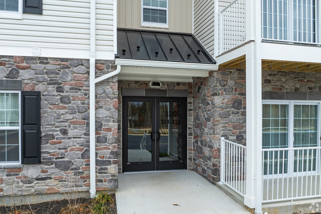 A house with a black door and a white railing.