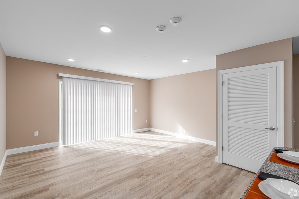 A room with wooden flooring and a white door.