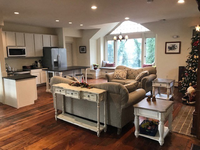 a living room and kitchen with a christmas tree