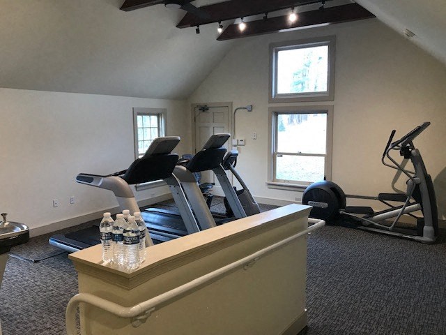 a gym with a row of exercise equipment in a room
