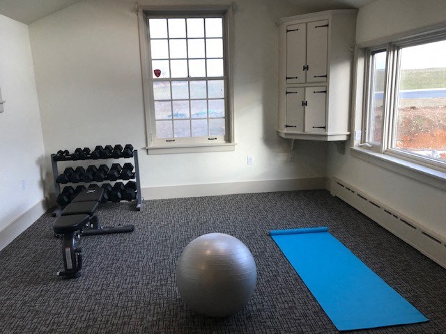 an empty gym with a ball and yoga mats