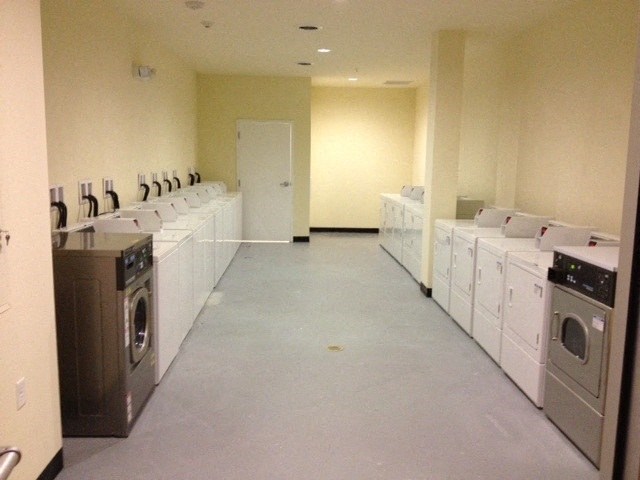 an empty laundry room with washing machines and dryers