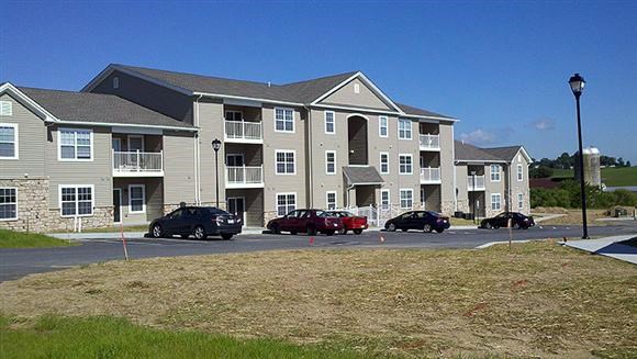 an apartment building with cars parked in front of it
