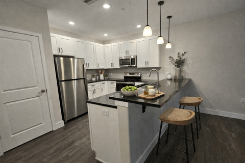 A kitchen with white cabinets and a stainless steel refrigerator.