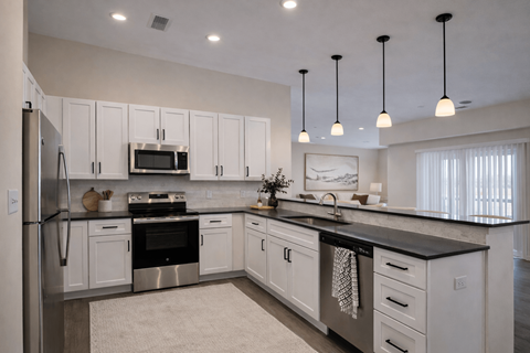 A modern kitchen with white cabinets and stainless steel appliances.