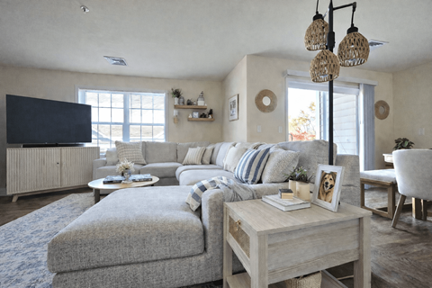 A living room with a grey couch and a wooden coffee table.